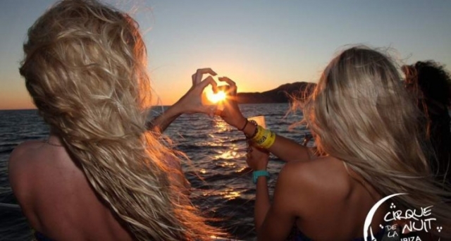 dos chicas haciendo un corazon con el sol de fondo